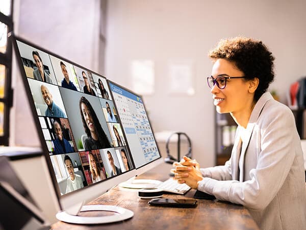 Business Remote Workers Features 600x450 Woman in front of two monitors on a video call